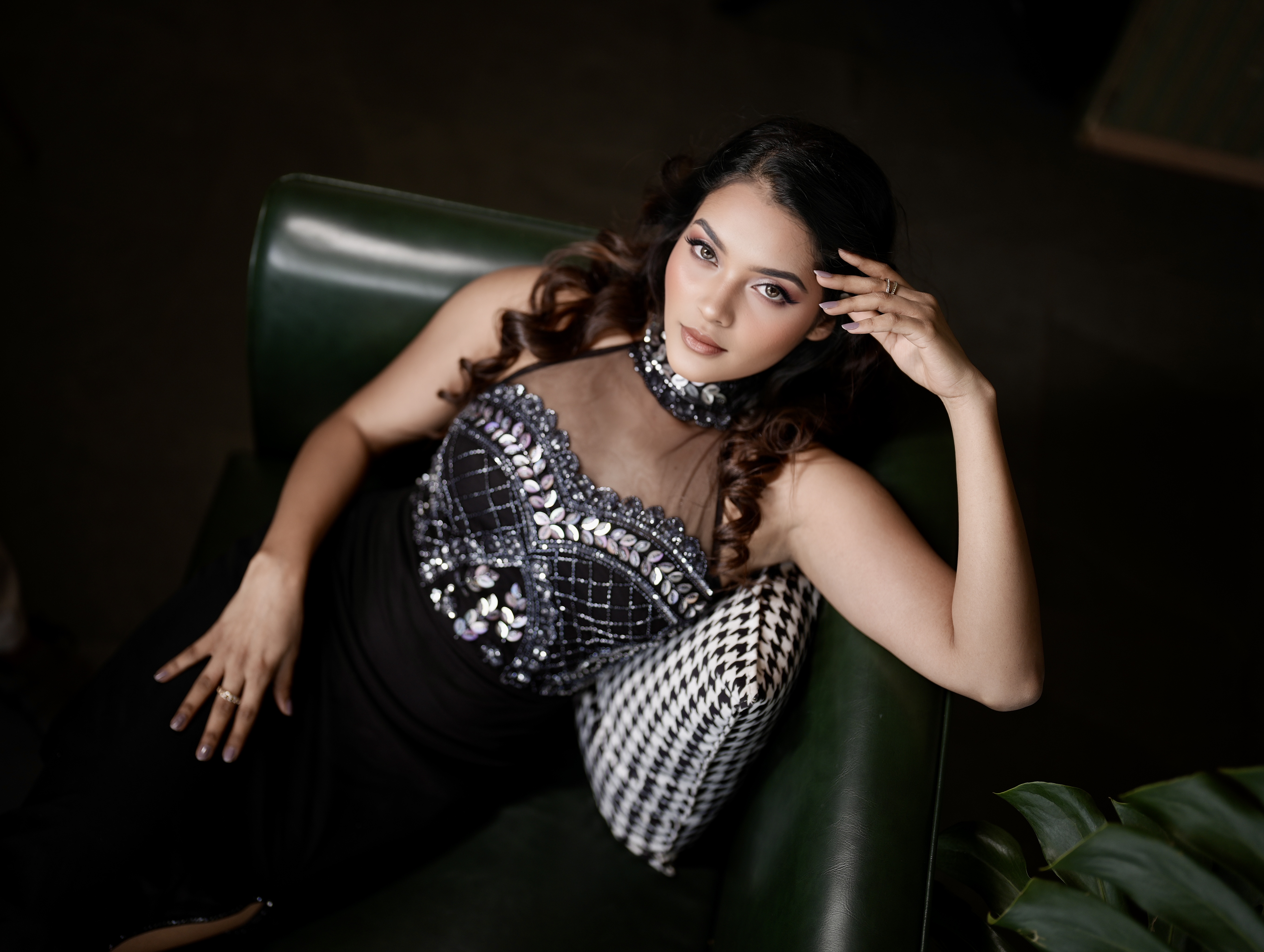 Editorial fashion portrait reclining in a dark green interior