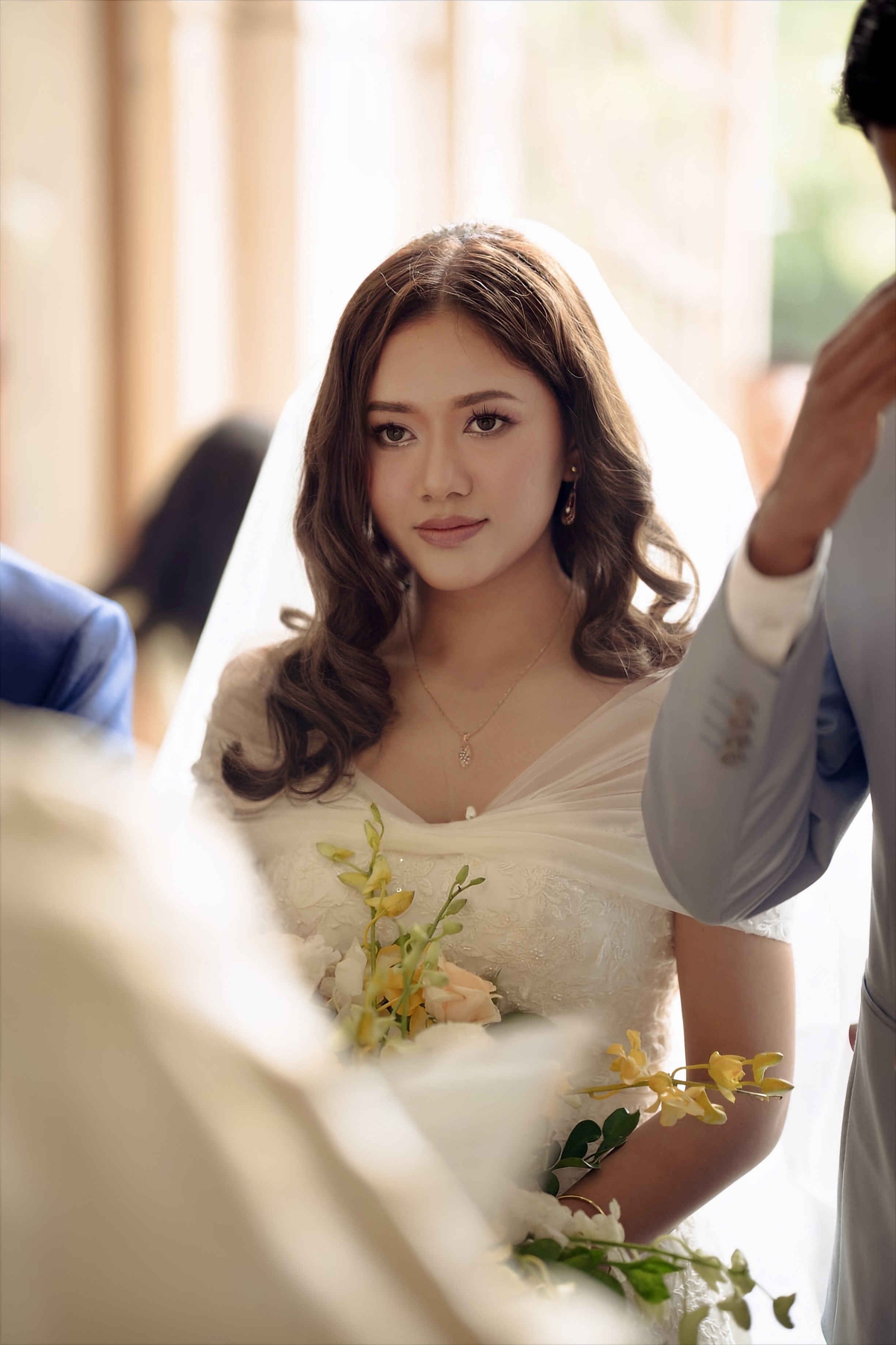 Bride held in a quiet moment among people before a ceremony